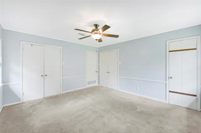 a view of a room with a ceiling fan and a window