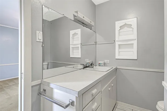 a bathroom with a sink a toilet and a mirror