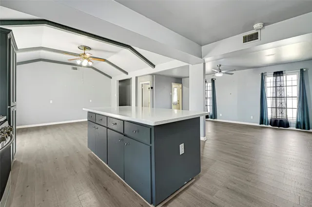a kitchen with granite countertop a stove and a wooden floors