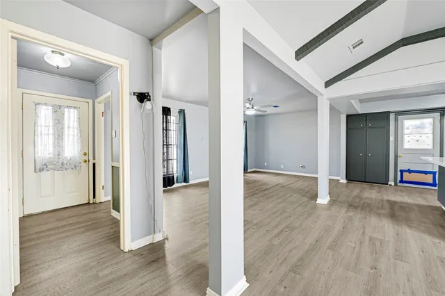 a view of a hallway with wooden floor and windows