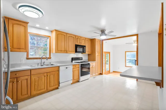 a large kitchen with stainless steel appliances granite countertop a stove sink and cabinets