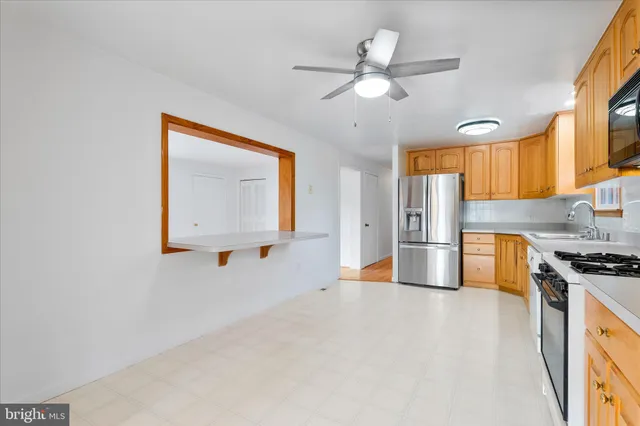a view of kitchen with stainless steel appliances granite countertop cabinets and a window