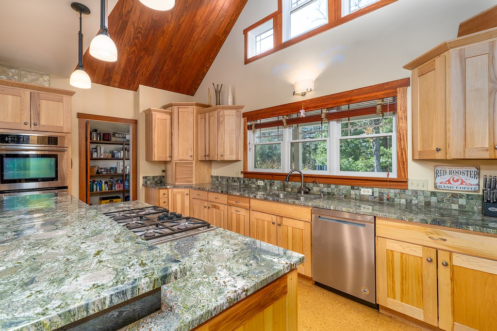 1 Scenic Ridge Court Coventry, RI 02816 - Photo 20 of 42 Kitchen displaying propane fueled stove-top cooking, granite counters, tiled backsplash and cathedral ceiling.