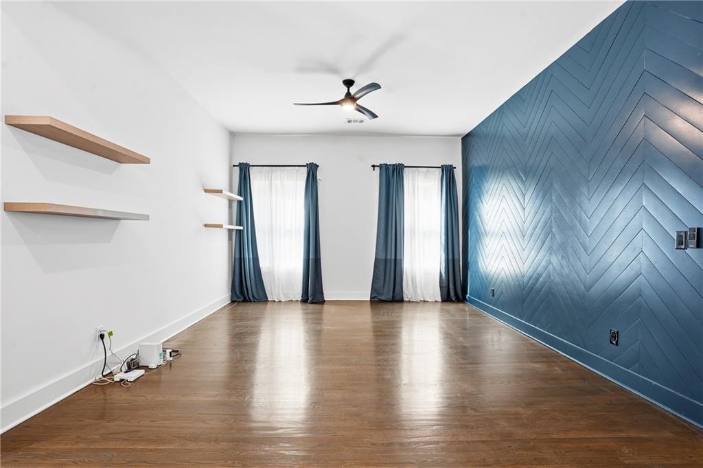 1025 Oak Street Southwest Atlanta, GA 30310 - Photo 11 of 30 an empty room with wooden floor chandelier fan and windows