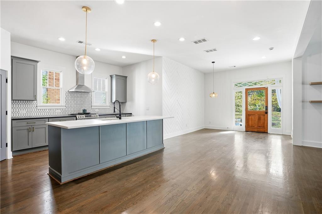 1025 Oak Street Southwest Atlanta, GA 30310 - Photo 13 of 30 a large kitchen with granite countertop a large center island a sink dishwasher and a stove with wooden floor
