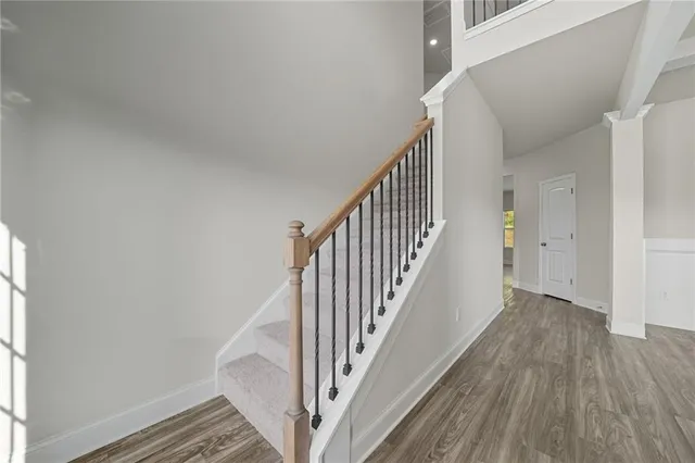a view of staircase with wooden floor and white walls