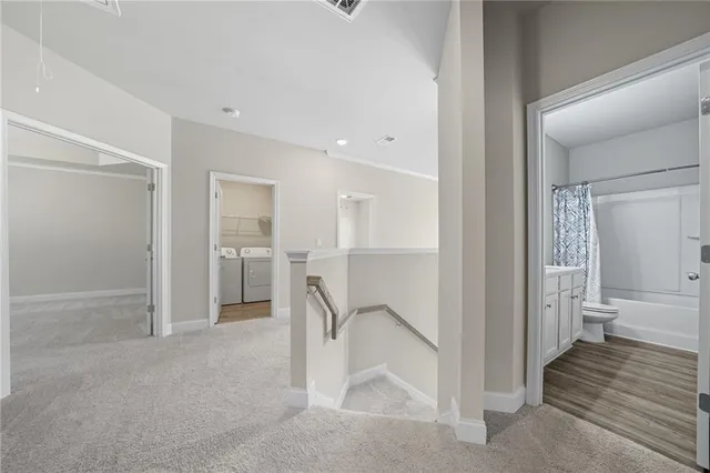 a view of a hallway with a livingroom and a bathroom