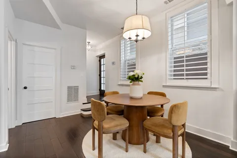 a dining room with furniture a chandelier and wooden floor
