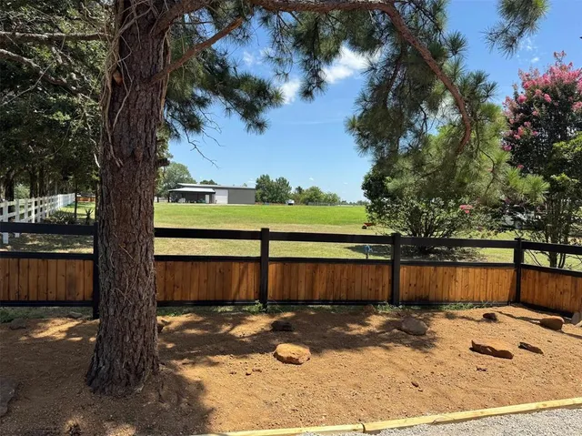 a view of a yard with wooden fence