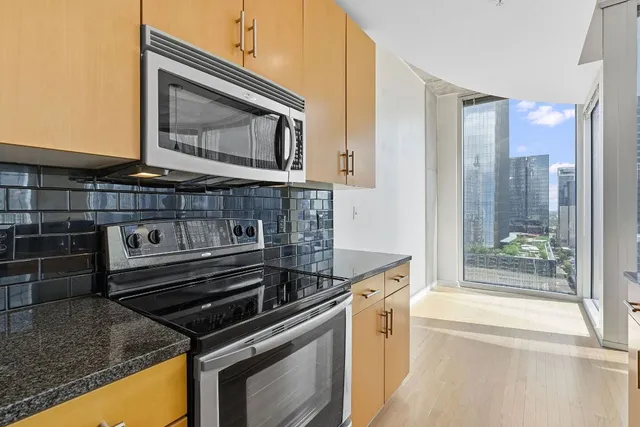 a kitchen with stainless steel appliances granite countertop a stove a sink and a refrigerator