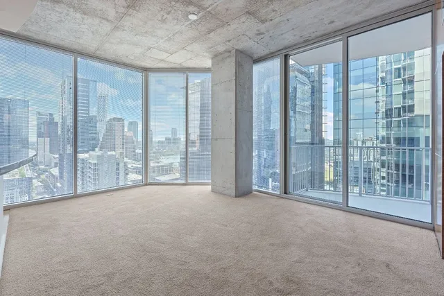 a view of an empty room with windows and a balcony