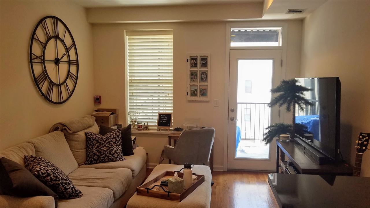 525 Adams Street, Unit 4L Hoboken, NJ 07030 - Photo 5 of 7 a living room with furniture a window and a flat screen tv