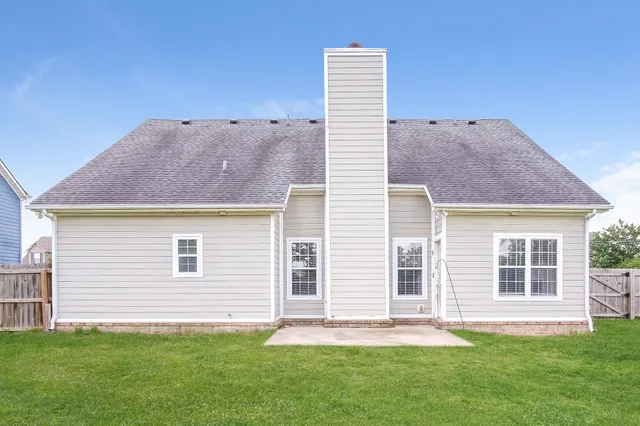 a backyard of a house with table and chairs