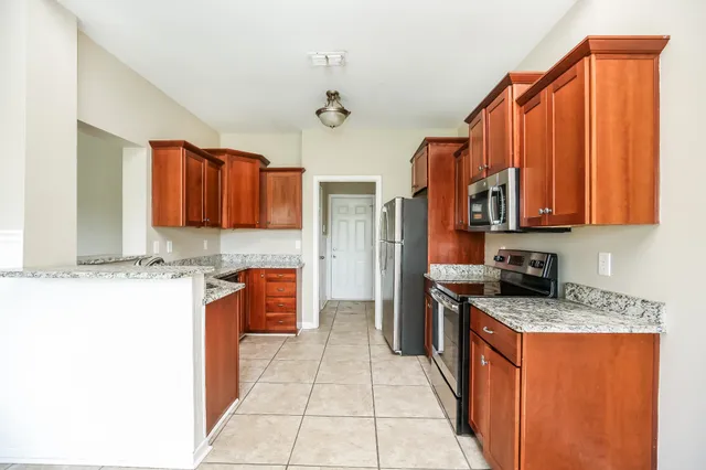 a kitchen with stainless steel appliances granite countertop a refrigerator and a stove top oven