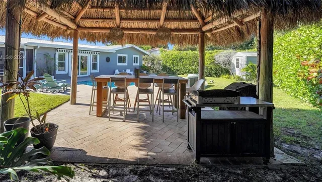 a view of a house with backyard and sitting area