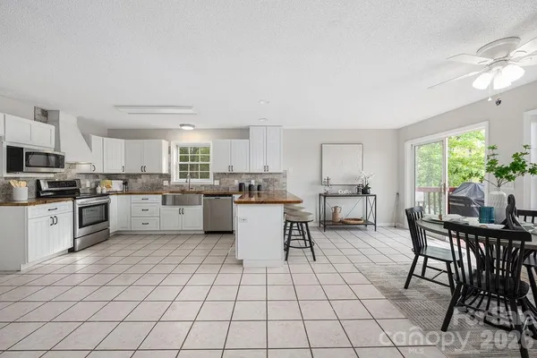 a kitchen with stainless steel appliances a table and chairs in it