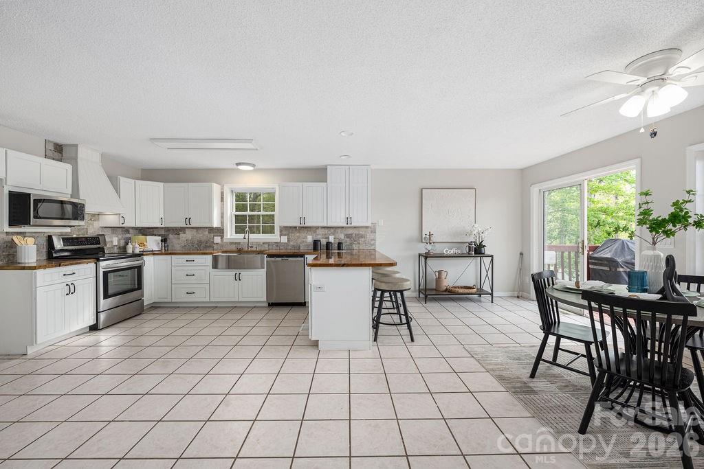 349 Lake Wylie Road Belmont, NC 28012 - Photo 13 of 48 a kitchen with stainless steel appliances a table and chairs in it