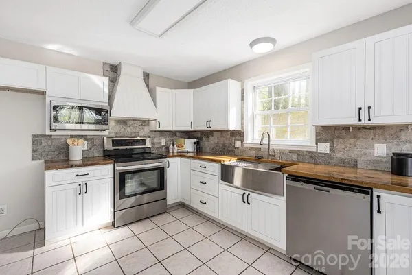 a kitchen with cabinets appliances a sink and a window