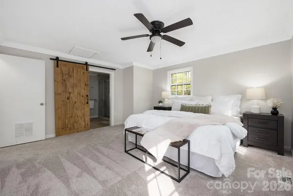 a spacious bedroom with a bed and a chandelier