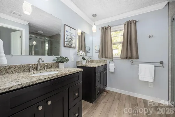 a bathroom with a granite countertop sink double vanity and a mirror