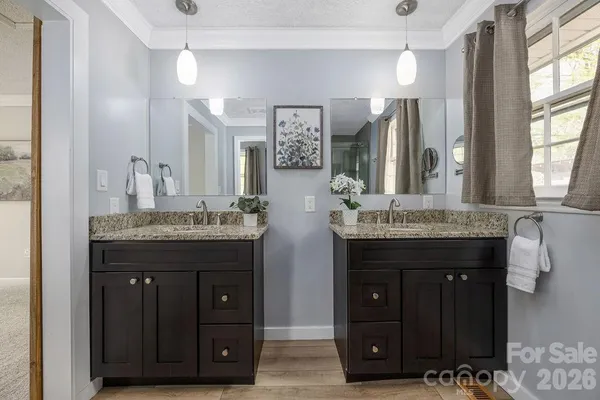 a bathroom with a granite countertop double vanity sink and a mirror