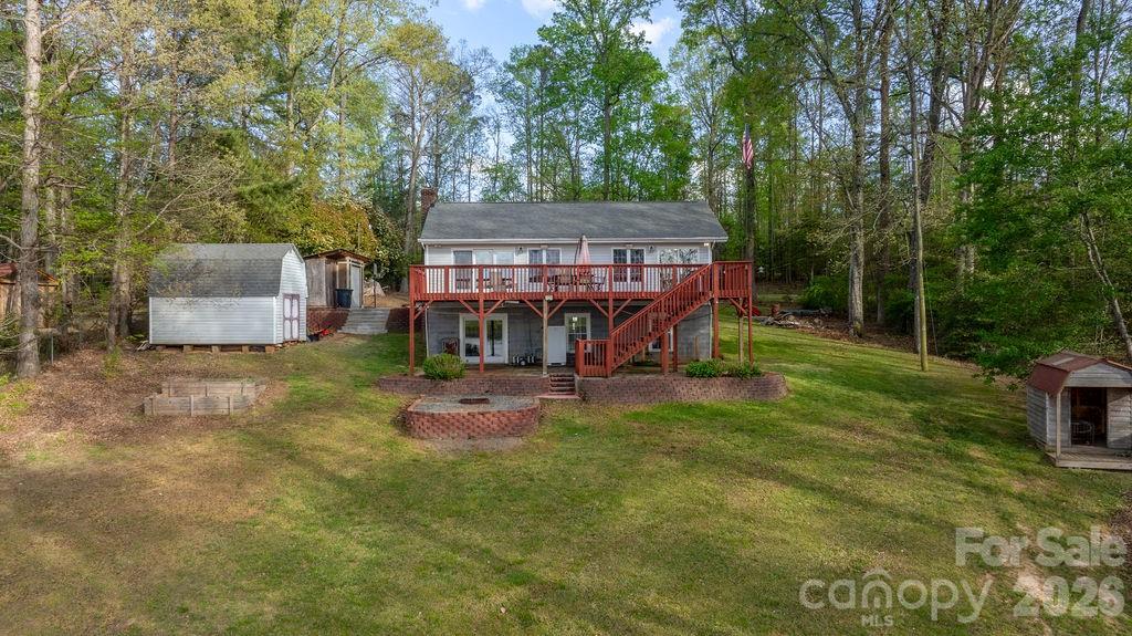 349 Lake Wylie Road Belmont, NC 28012 - Photo 3 of 48 a view of a backyard with a small cabin and a chair