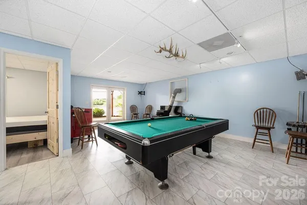 a room with furniture pool table flat screen tv and a chandelier