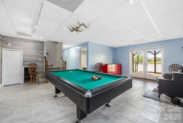 a room with pool table and windows