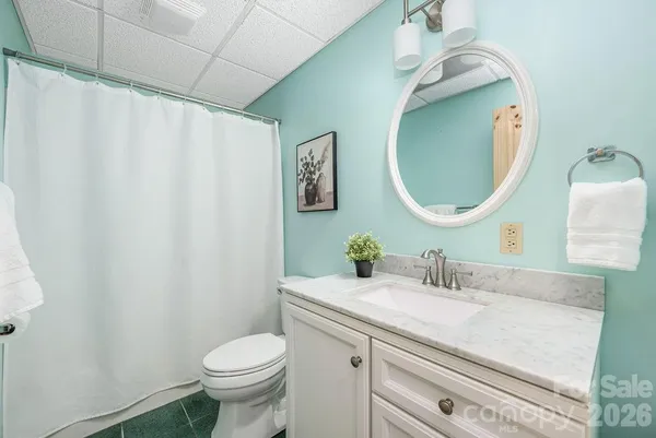 a bathroom with a granite countertop toilet sink and mirror