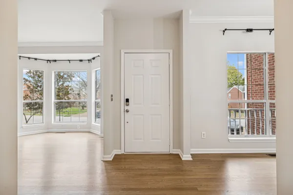a view of an empty room with wooden floor fireplace and a window