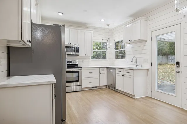 a view of a hallway with wooden floor and staircase