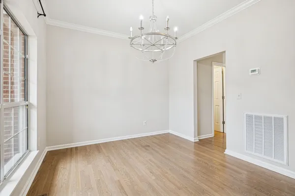 a view of a room with wooden floor and a ceiling fan