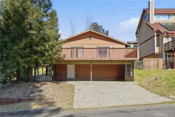 a front view of a house with a yard and trees