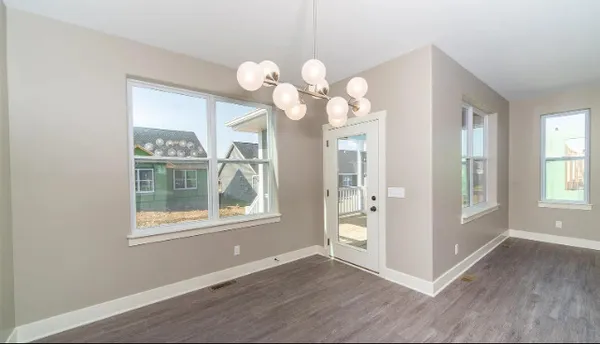 a large kitchen with kitchen island a stove a sink dishwasher and a refrigerator with wooden floor