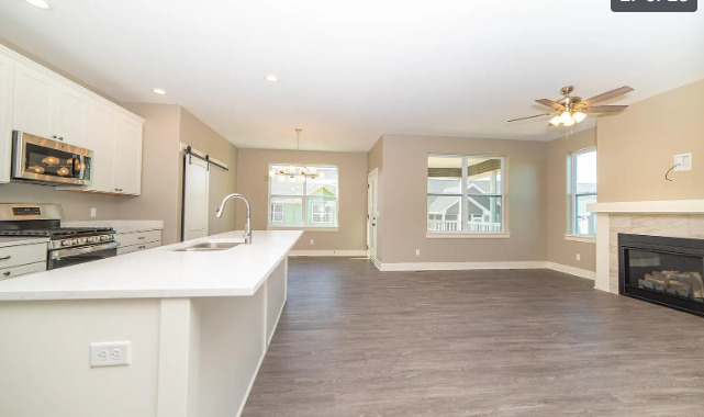 7235 Genesis Way Bettendorf, IA 52722 - Photo 26 of 26 a large kitchen with a stove a sink a refrigerator and a fireplace