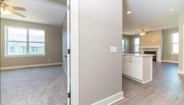 7235 Genesis Way Bettendorf, IA 52722 - Photo 4 of 26 an empty room with wooden floor and a kitchen