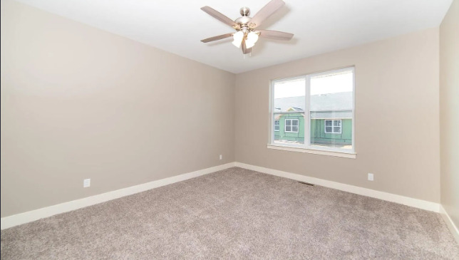 7235 Genesis Way Bettendorf, IA 52722 - Photo 5 of 26 an empty room with windows and ceiling fan