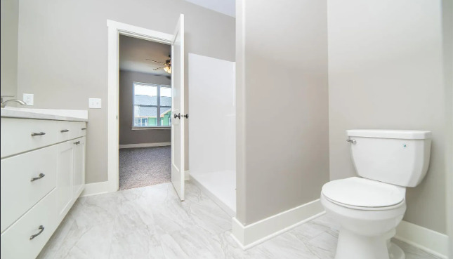 7235 Genesis Way Bettendorf, IA 52722 - Photo 8 of 26 a bathroom with a toilet a sink and a vanity
