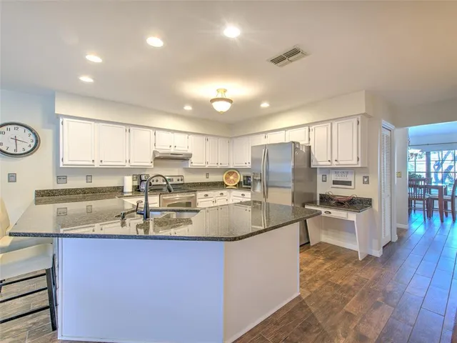 a kitchen with stainless steel appliances granite countertop a sink stove and refrigerator