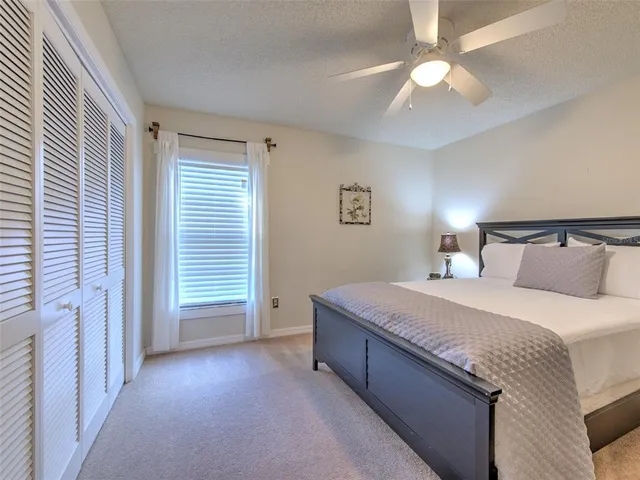 a spacious bedroom with a bed and a chandelier