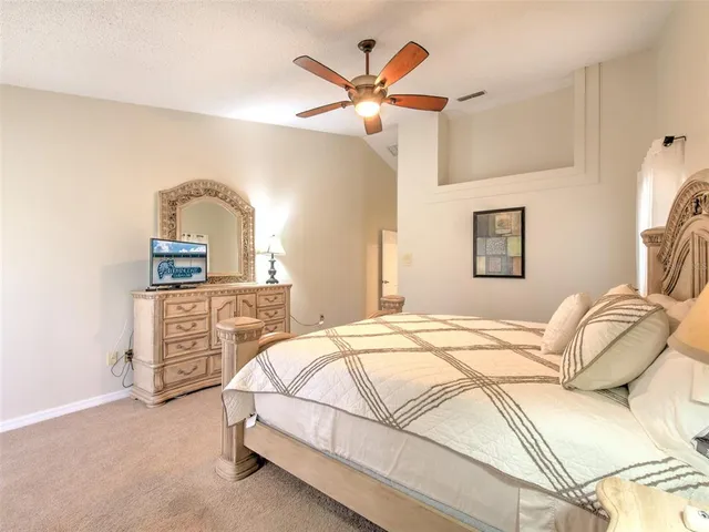 a bedroom with a bed a dresser and ceiling fan