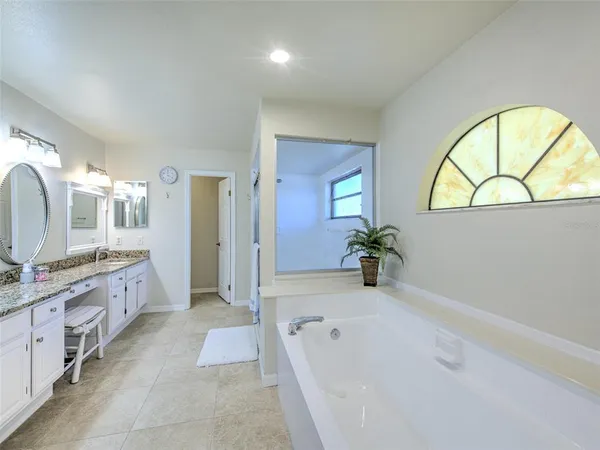 a bathroom with a tub sink and mirror