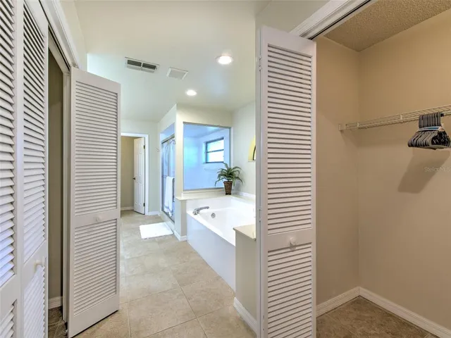 a bathroom with a tub sink and mirror