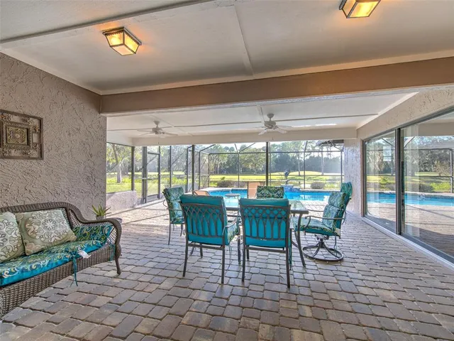 a dining room with furniture and a floor to ceiling window