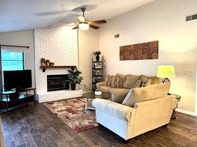 a living room with furniture a flat screen tv and a fireplace