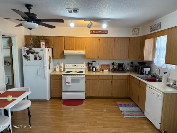 a kitchen with granite countertop a sink appliances cabinets and furniture
