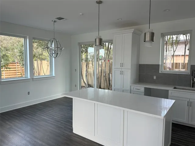 a view of a kitchen with granite countertop a sink and wooden floor