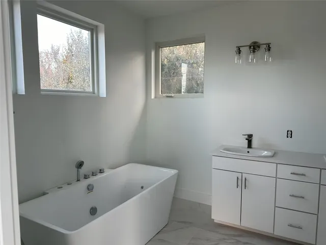 a bathroom with a bathtub sink and mirror
