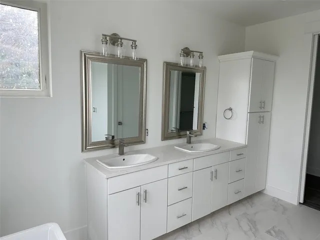 a bathroom with double sink and a mirror