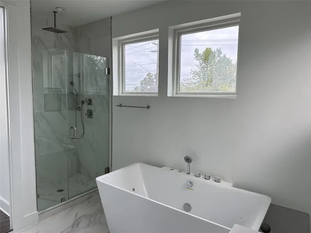 a white bath tub sitting next to a shower
